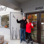 Owners of 2 Loons Distillery in front of the building, hugging and smiling