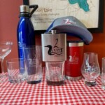 Merchandise: Cups/Glasses of various sizes, Flasks, Hat, Tumbler, and water bottle.